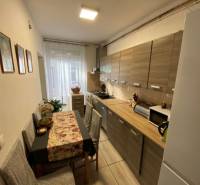 V exkluzívnom zastúpení majiteľa ponúkame na predaj rodinný dom - Kuchyňa v rodinnom dome s podlahou s dreveným dekorom, stôl a spotrebiče.