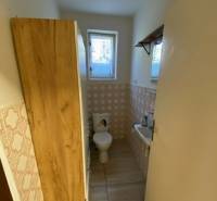 V exkluzívnom zastúpení majiteľa ponúkame na predaj rodinný dom - Kúpeľňa s toaletou v rodinnom dome. Dlažba s dekorom dreva, okno a umývadlo.