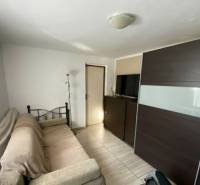 V exkluzívnom zastúpení majiteľa ponúkame na predaj rodinný dom - Obývacia izba v rodinnom dome s gaučom, veľkou skriňou a podlahou s dreveným dekorom.