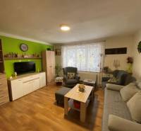 V exkluzívnom zastúpení majiteľa ponúkame na predaj rodinný dom - Obývacia izba v rodinnom dome s podlahou s dreveným dekorom, pohodlnými sedačkami a dekoráciami.