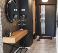 Exkl.4 iz novostavba RD - tepelné čerpadlo - Moravany nad Váhom - Vstupná hala s okrúhlym zrkadlom, drevenou konzolou a dekoratívnymi prvkami v rodinnom dome.