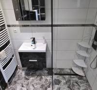 SLOVREAL - Predaj rodinného domu - Handlová - Kúpeľňa v rodinnom dome s bielymi dlaždicami a sprchovým kútom.