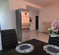 SLOVREAL - Predaj rodinného domu - Handlová - Jedáleň s kvetmi a kuchyňa s bielymi dlaždicami v rodinnom dome.