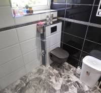 SLOVREAL - Predaj rodinného domu - Handlová - Kúpeľňa v rodinnom dome s čiernymi a bielymi dlaždicami a praktickým zariadením.