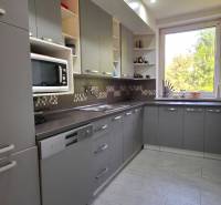 SLOVREAL - Predaj rodinného domu - Handlová - Kuchyňa v rodinnom dome s sivými skrinkami, veľkým oknom a spotrebičmi.