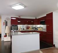 Predaj, rodinný dom Trebišov, NOVÁ SKVELÁ CENA ul. J... - Kuchyňa v rodinnom dome s lesklou červenou linkou a kuchynským ostrovom.