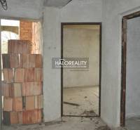 Predaj, rodinný dom Dolný Pial - VO VÝSTAVBE - Interiér rodinného domu s nedokončenou tehlovou stenou a surovými múrmi.