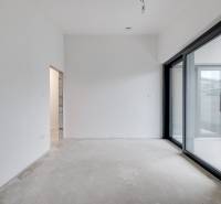 Novostavba samostatne stojaceho RD v štandarde, nízka spotreba - Interiér rodinného domu s veľkým posuvným skleneným oknom a neukončenou podlahou.