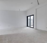 Novostavba samostatne stojaceho RD v štandarde, nízka spotreba - Prázdna miestnosť v rodinnom dome s veľkými presklenými dverami a čistými bielymi stenami.