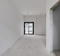 Novostavba samostatne stojaceho RD v štandarde, nízka spotreba - Prázdna miestnosť s bielymi stenami, betónovou podlahou a veľkým oknom v rodinnom dome.