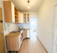 Na predaj 2,5- izbový byt Žilina-Solinky - Kuchyňa v 2-izbovom byte s podlahou s dreveným dekorom a bielymi skrinkami.