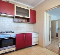 PRIESTRANNÝ 1-IZBOVÝ BYT, 38 M², BANSKÁ BYSTRICA - SITNIANSKA - Kuchyňa v 1-izbovom byte s červenobielymi skrinkami, rúrou a plynovým sporákom.