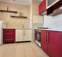 PRIESTRANNÝ 1-IZBOVÝ BYT, 38 M², BANSKÁ BYSTRICA - SITNIANSKA - Kuchyňa v 1-izbovom byte s bielymi a červenými skrinkami a dlažbou.