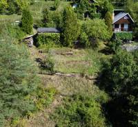 ZÁHRADA S UNIMOBUNKOU A VÝHĽADOM NA ZVOLEN , 465M2, ZVOLEN – HÁJIK - Záhrady v lokalite Hájik v meste Zvolen, obklopené hustou zelenou vegetáciou.