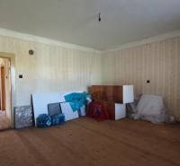 Rodinný dom v obci Čebovce v okrese Veľký Krtíš. - Interiér rodinného domu s podlahou s dreveným dekorom, nevyužitý priestor plný pomôcok.