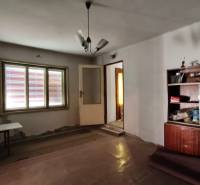 Rodinný dom v obci Čebovce v okrese Veľký Krtíš. - Izba v rodinnom dome s jednoduchým nábytkom a lampou na strope.