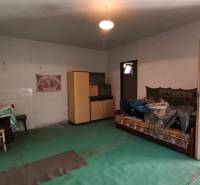 Rodinný dom v obci Čebovce v okrese Veľký Krtíš. - Izba v rodinnom dome s umývadlom, stoličkami, pohovkou a šatníkovou skriňou.