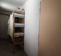 Rodinný dom v obci Čebovce v okrese Veľký Krtíš. - Úzka chodba s policami v rodinnom dome, jednoduché zariadenie.