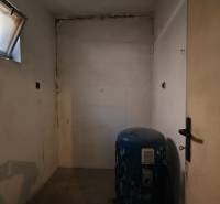 Rodinný dom v obci Čebovce v okrese Veľký Krtíš. - Prázdna miestnosť s oknom a nádržou v rodinnom dome.