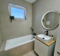 PREDAJ - 2-izbový byt v nádhernej lokalite Dvorníky - Kúpeľňa s vaňou, umývadlom a okrúhlym zrkadlom v 2-izbovom byte.