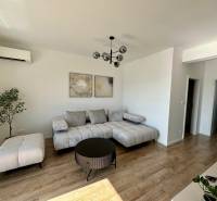 PREDAJ - 2-izbový byt v nádhernej lokalite Dvorníky - Obývacia izba v 2-izbovom byte s podlahou s dreveným dekorom a šedým nábytkom.