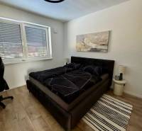 PREDAJ - 2-izbový byt v nádhernej lokalite Dvorníky - Spálňa v 2-izbovom byte so štýlovým lusterom a podlahou s dreveným dekorom.