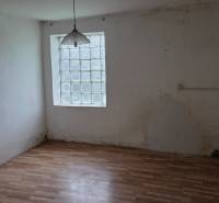 Na predaj 5 izbový rodinný dom Vinohrady nad Váhom - Miestnosť rodinného domu s podlahou s dreveným dekorom a oknom z luxferov.