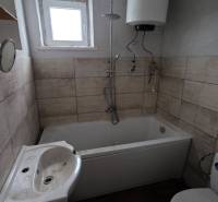 Na predaj 5 izbový rodinný dom Vinohrady nad Váhom - Kúpeľňa v rodinnom dome s vaňou, umývadlom a bojlerom, podlaha s dreveným dekorom.