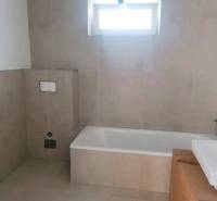 Novostavba- 3i dom s dvorom s nízkou údržbou - Kúpeľňa v rodinnom dome s obkladom a vaňou.