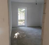 Novostavba- 3i dom s dvorom s nízkou údržbou - Interiér rodinného domu s pohľadom na prázdnu miestnosť a záhradu.