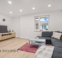 REZERVOVANÉ | NA PREDAJ 3-IZBOVÝ BYT S BALKÓNOM, VRAKÚŇ - Obývacia izba s rohovou sedačkou, podlahou s dreveným dekorom a televízorom v 3-izbovom byte.