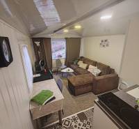 Pohoda pri vode, chata s výhľadom na Domašu - Interiér chaty s pohovkou, jedálenským stolom a vybavenou kuchyňou.