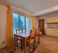 Apartmán, Nová Lesná, 46m2 + balkón, park. miesto, zariadený  - Rekreačný apartmán s jedálenským kútom, závesmi a podlahou s dreveným dekorom.