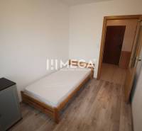 NA PRENÁJOM 1,5-IZB. BYT V MESTE HUMENNÉ - Spálňa s posteľou, komodou a podlahou s dreveným dekorom v 2-izbovom byte.