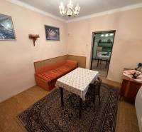 EXKLUZÍVNE Rodinný dom s veľkým potenciálom – Bešeňov - Jedáleň v rodinnom dome s kobercami, stolom a stoličkami, podlaha s dreveným dekorom.