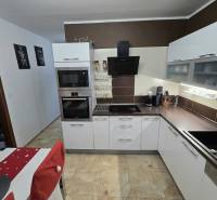 Predaj,trojizbový byt SNP, Holíč - Kuchyňa v 3-izbovom byte so svietidlami, bielymi skrinkami a dlažbou.
