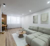 MICHALOVSKÁ:  moderný 3 izb. byt. REKONŠTRUKCIA, ZARIADENIE, LOGGIA.  - Obývacia izba 3-izbového bytu s pohodlnou pohovkou a podlahou s dreveným dekorom.