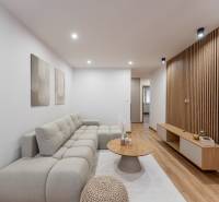 MICHALOVSKÁ:  moderný 3 izb. byt. REKONŠTRUKCIA, ZARIADENIE, LOGGIA.  - Obývacia izba v 3-izbovom byte s pohovkou a podlahou s dreveným dekorom.