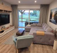 Na predaj 4 izbový RD v obci  Studienka, garáž, sauna, pozemok 719 m2 - Obývačka v rodinnom dome s podlahou s dreveným dekorom, rohovou pohovkou a televízorom.