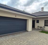 Na predaj 4 izbový RD v obci  Studienka, garáž, sauna, pozemok 719 m2 - Rodinný dom v Studienke s dvoma stoličkami a stolíkom na dláždenom dvore.