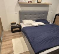 Na predaj 4 izbový RD v obci  Studienka, garáž, sauna, pozemok 719 m2 - Spálňa s podlahou s dreveným dekorom, posteľou a úložnými priestormi v rodinnom dome.