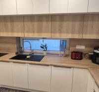 Na predaj 4 izbový RD v obci  Studienka, garáž, sauna, pozemok 719 m2 - Kuchyňa v rodinnom dome s bielymi skrinkami a pracovnou doskou s dreveným dekorom.