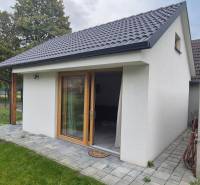 Na predaj 4 izbový RD v obci  Studienka, garáž, sauna, pozemok 719 m2 - Rodinný dom v Studienke s bielou fasádou a šikmou strechou, rámovaný zelenými stromami.