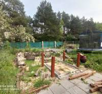 REZERVOVANÉ Chatka na krásnom mieste v kľudnom prostredí - Záhrada pri chate v Hliníku nad Hronom s trampolínou a dreveným chodníkom.