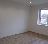 Ponúkame na predaj 4izb rodinný dom v štandarde v obci Radava - Izba v rodinnom dome s bielymi stenami a podlahou s dreveným dekorom.