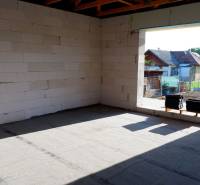 Ponúkame na predaj štvorizbový rodinný dom v obci Radava. - Výstavba rodinného domu v Radave s pohľadom na neomietnuté steny a okolitú krajinu.