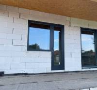 Ponúkame na predaj štvorizbový rodinný dom v obci Radava. - Nedokončená fasáda rodinného domu v Radave s plastovými dverami a oknami.