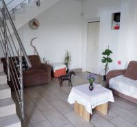 Ponúkame na predaj penzión v Poľnom Kesove - Interiér s pohovkou, stolom, rastlinami a schodmi v Hotely a penzióny.