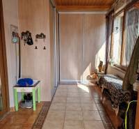 Krásny rodinný dom s rozľahlým pozemkom - Chodba s dlažbou, vstavanou skriňou a lavicou v rodinnom dome.