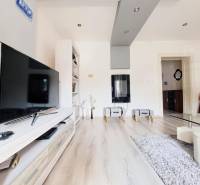 Domov, kde si vytvoríte vlastný príbeh – rodinný dom na predaj, Neded - Obývacia izba v rodinnom dome s televízorom a podlahou s dreveným dekorom.